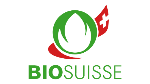 Logo von Bio Suisse. Text in grüner Schrift auf weissem Grund. Darüber die Knospe von Bio Suisse, ummantelt vom Schweizerkreuz.